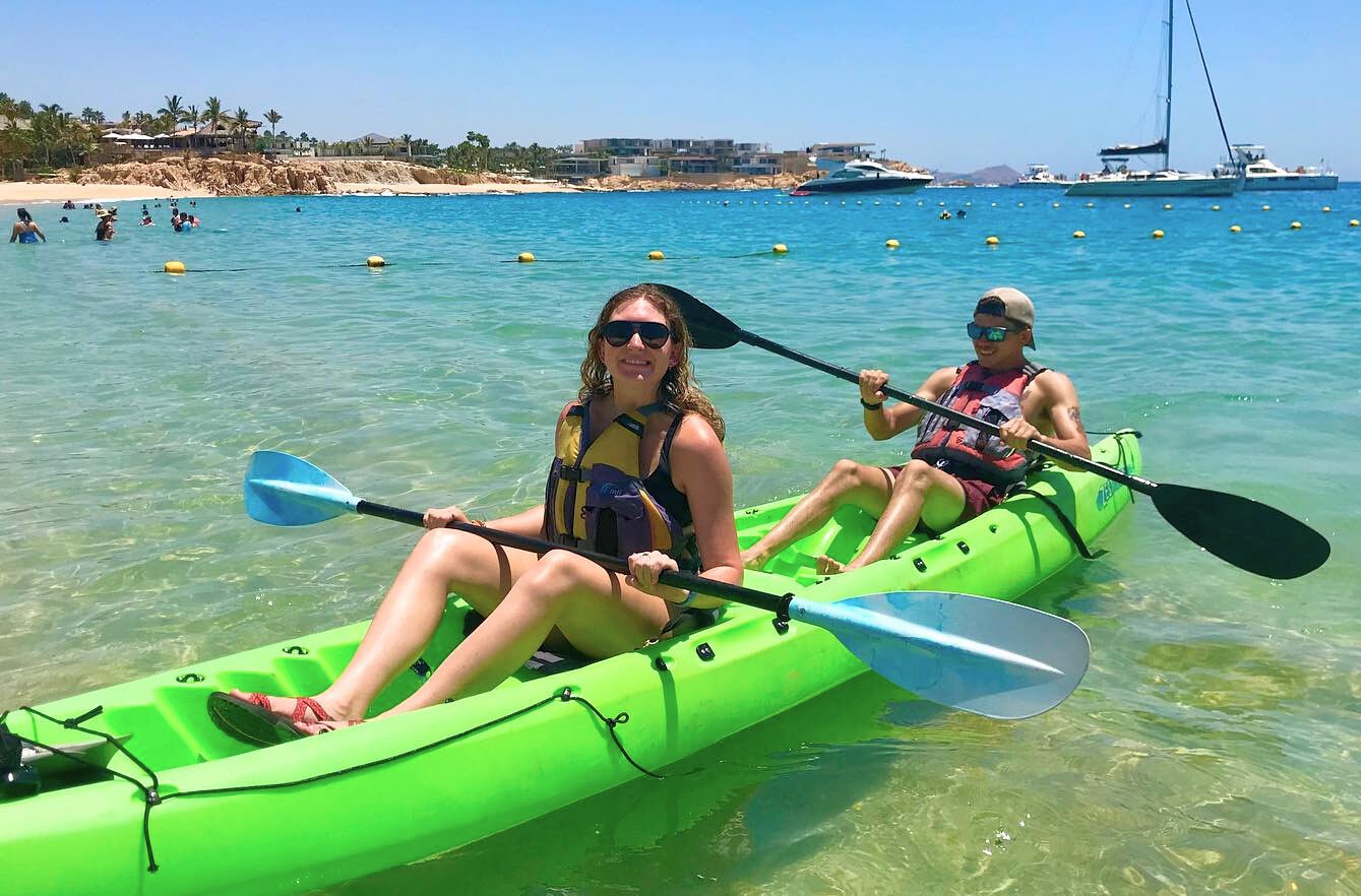 Couple paddling a green kayak in Chileno Bay