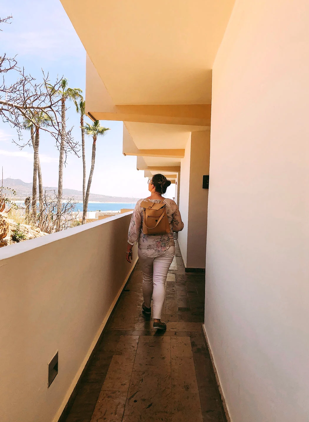Woman walks along a corridor at a hotel in cabo San Lucas