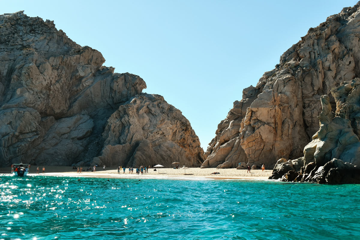Turquoise waters lap the golden sands of Lover's Beach, Cabo San Lucas