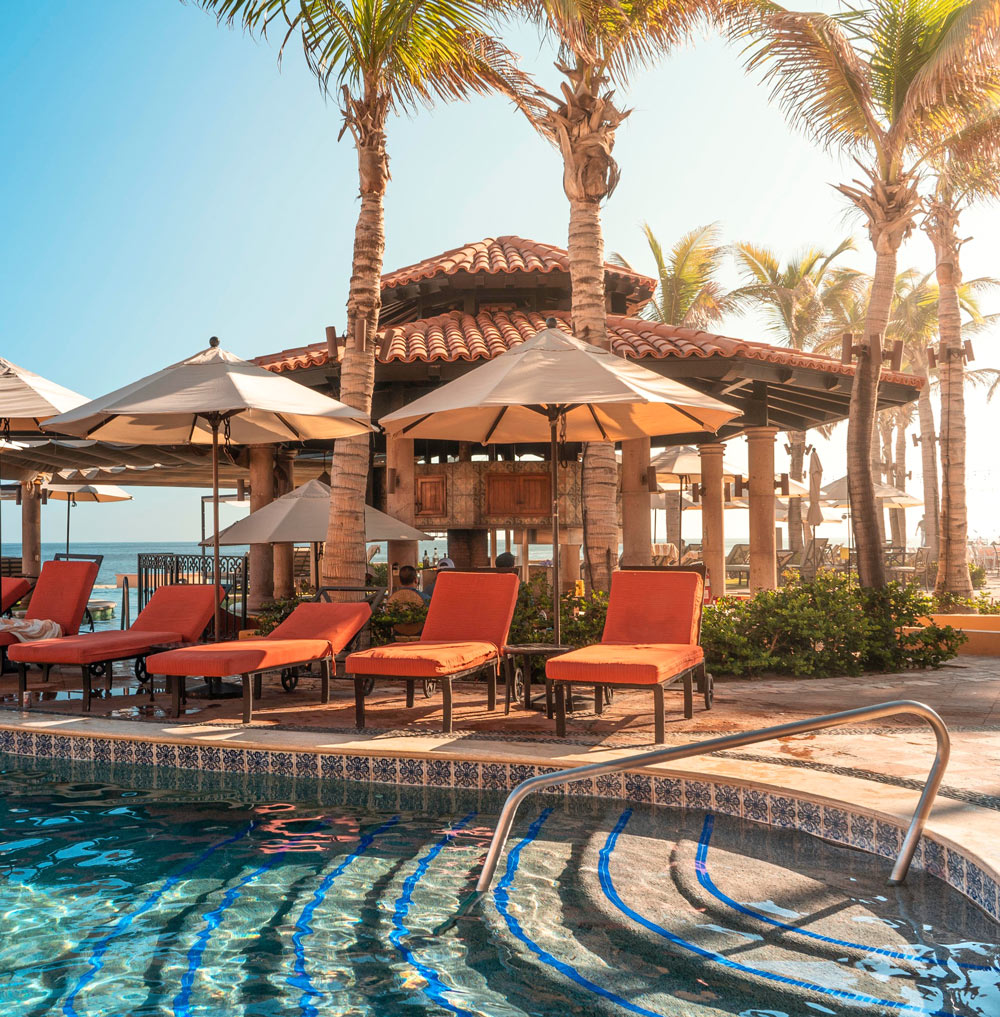 Orange cushioned pool chairs by the pool at Playa Grande Resort