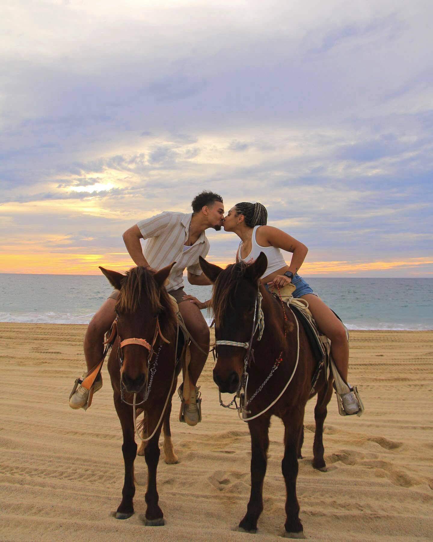 Couple kissing while horsebacking riding in Cabo
