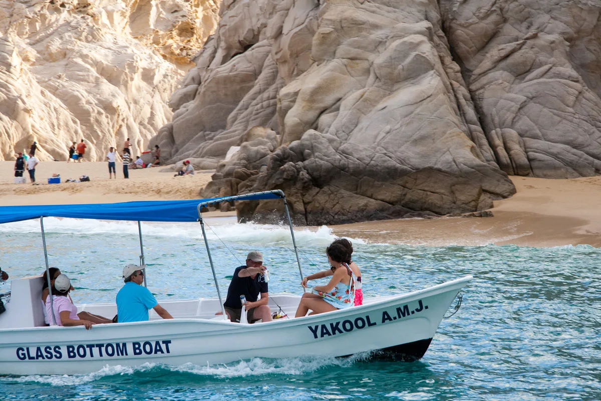 A glass bottom boat cruises past Land's End in Cabo San Lucas