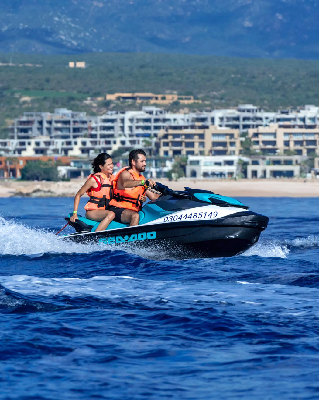 Couple whizzing across the water on a jet ski in Cabo San Lucas
