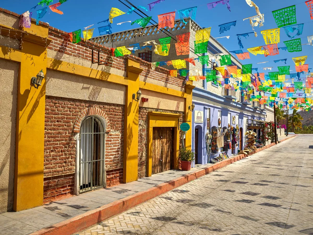 Colorful flags above a cobblestone street in Todos Santos, Mexico