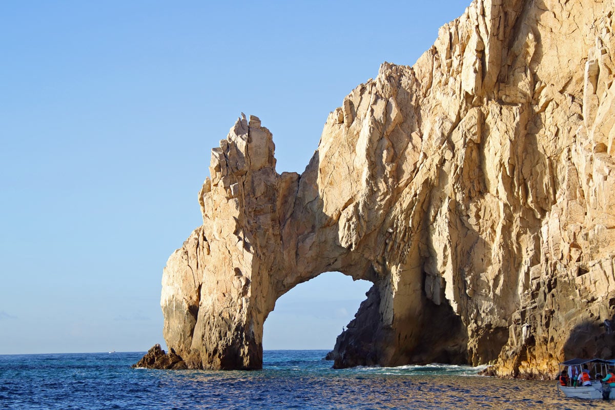 A water taxi putters by the Arch in  Cabo San Lucas.