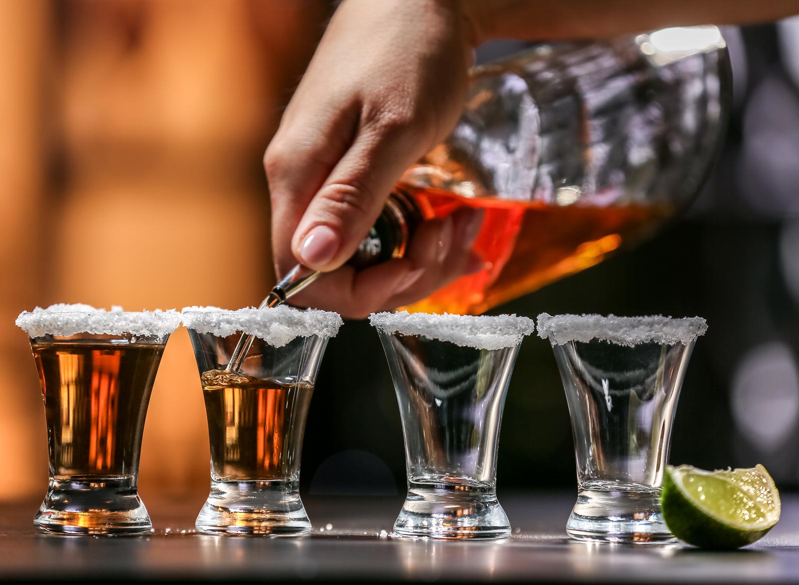 A bartender pours tequila shots