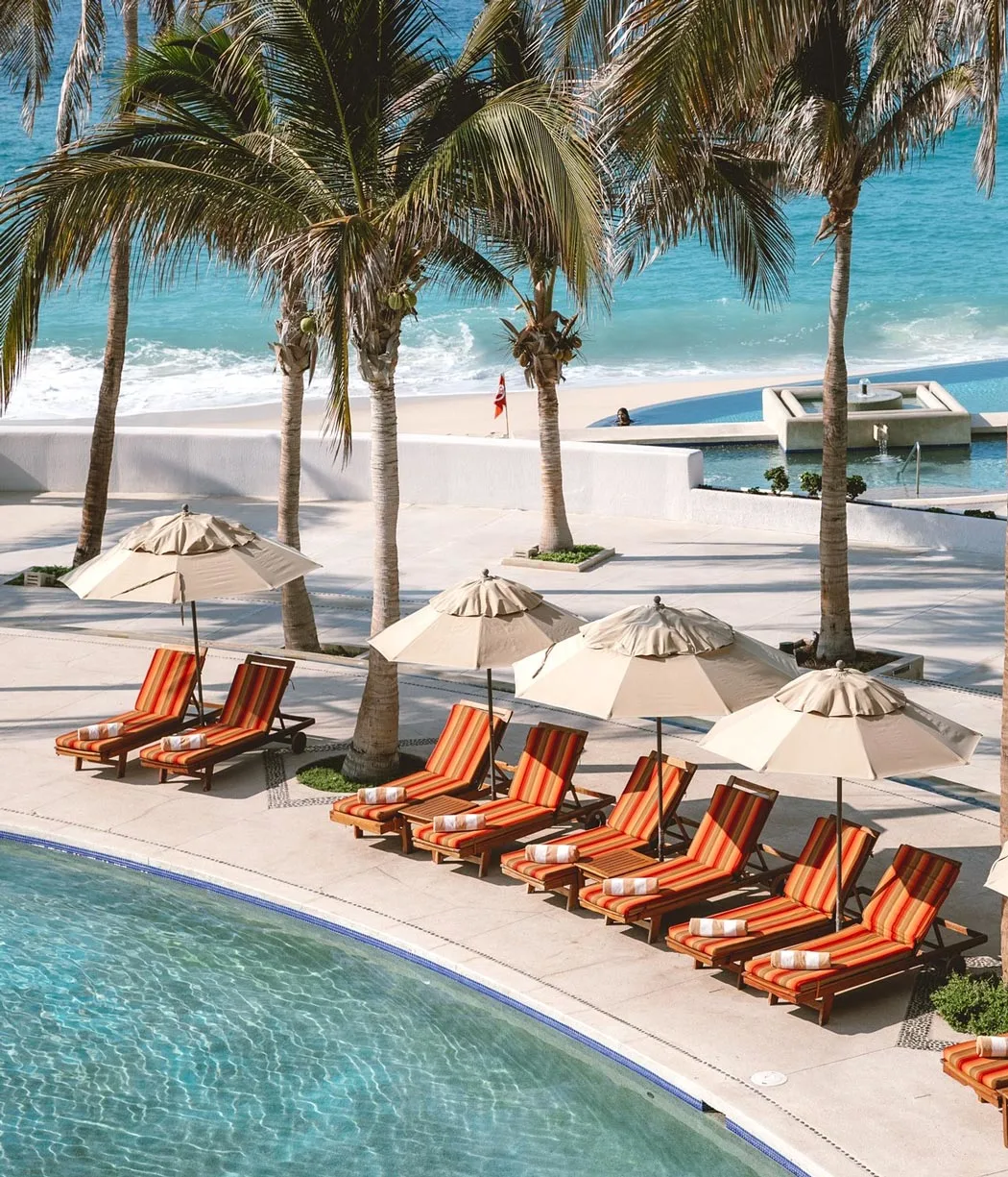 Marquis Los Cabos pool with pool chairs, covered in orange cushions