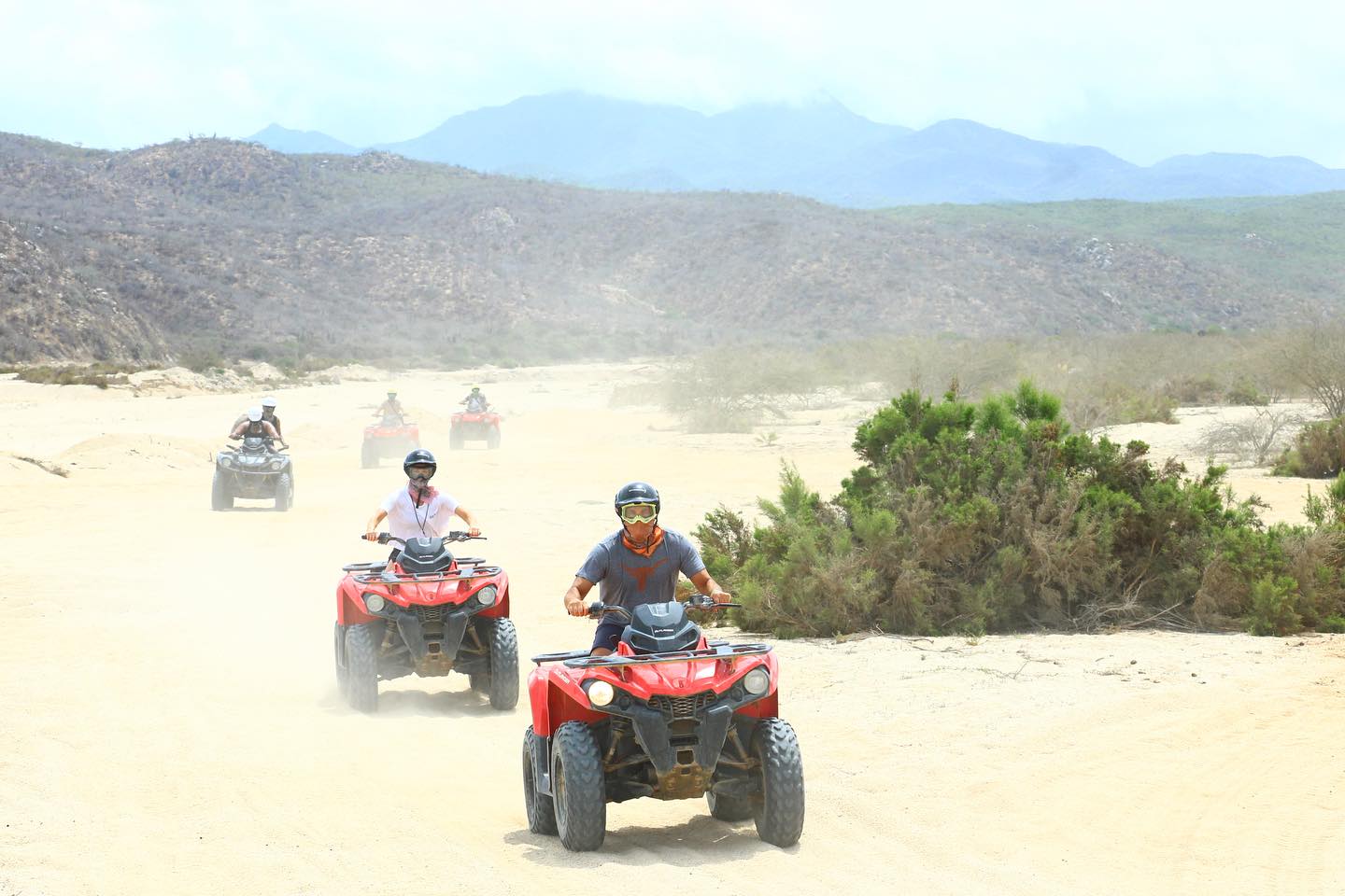 Red ATVs roar across the Migrino Desert near Cabo San Lucas.