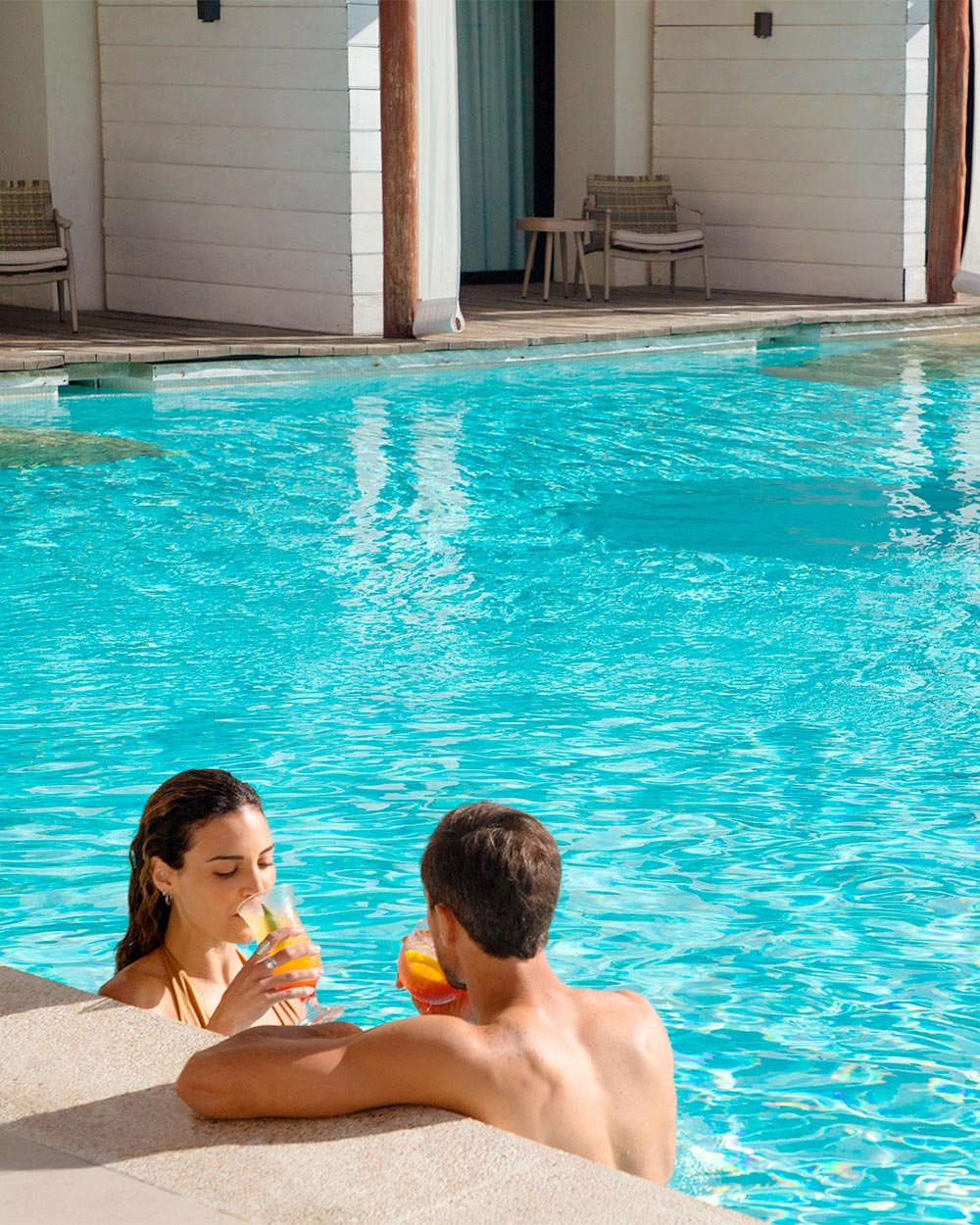Couple sipping cocktails while in the pool