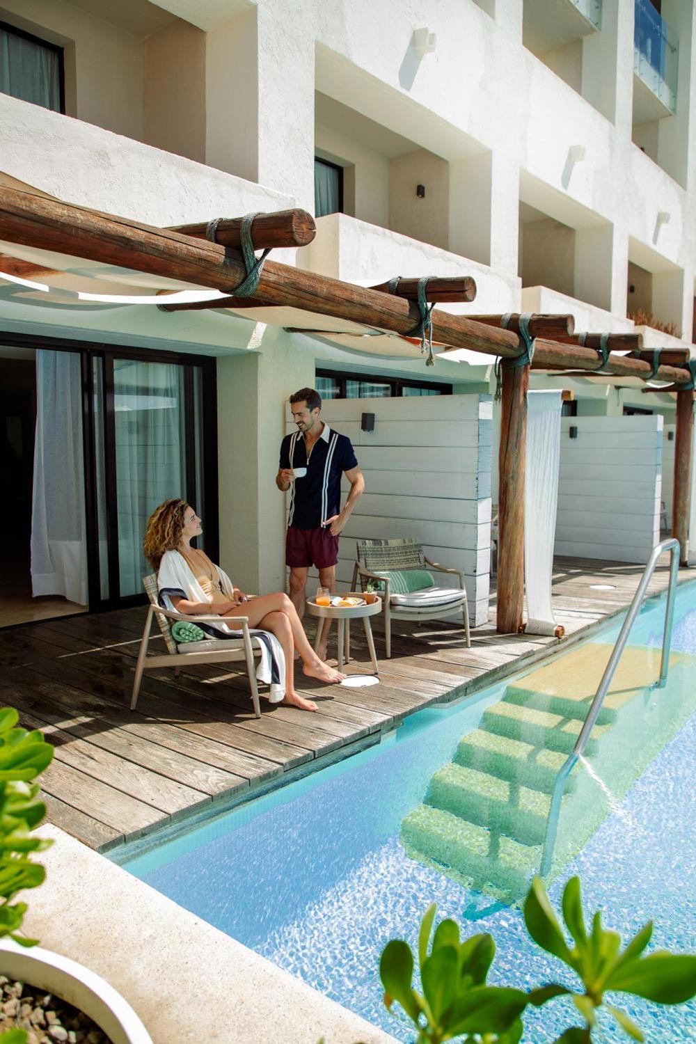 Couple having coffee on their deck of a swim-up room at Paradisus in Los Cabos