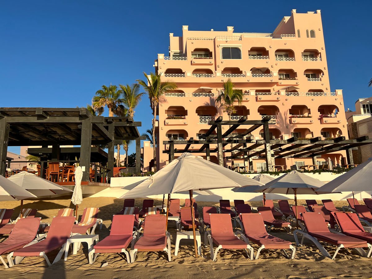 Pink beach chairs of Pueblo Bonito Rose on the sand at sunset