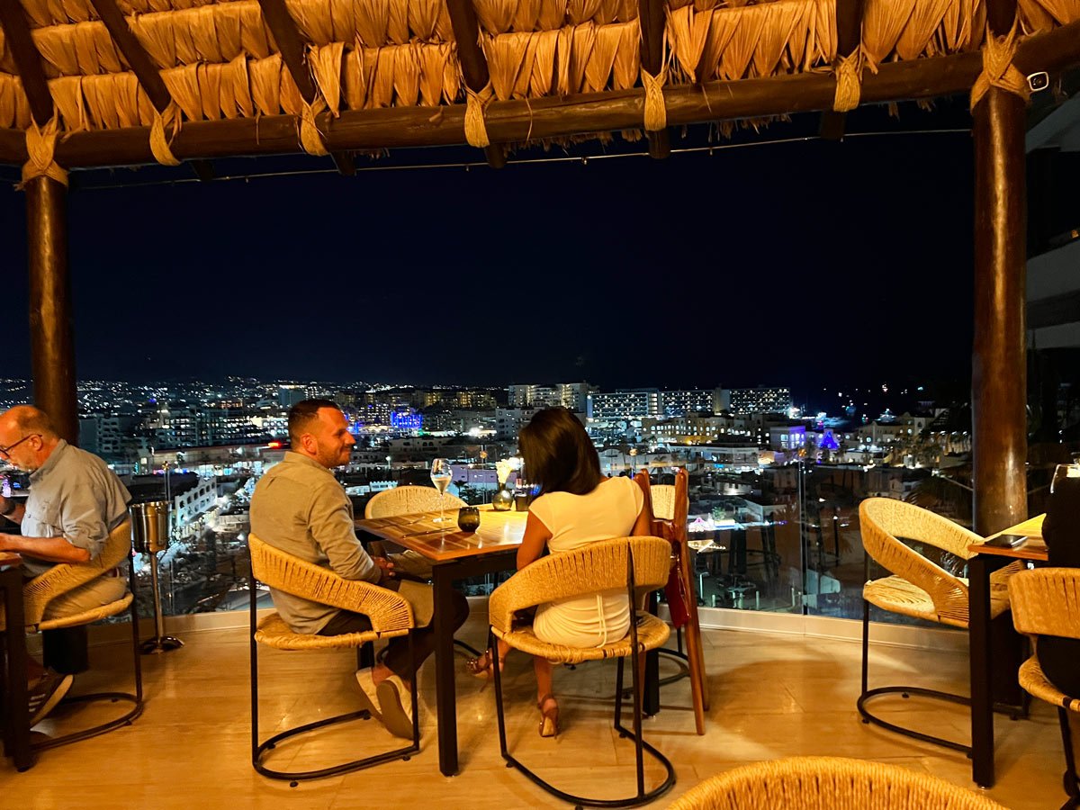 Couple dining at a high-end Pedregal restaurant in Cabo with a city view