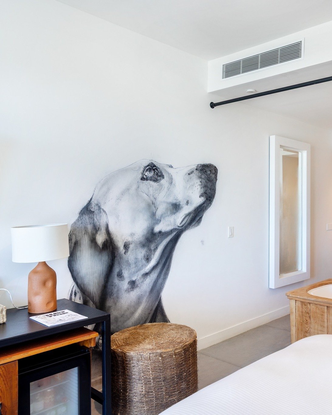 Black-and-white sketch of a dog painted on the wall of a Hotel El Ganzo guestroom