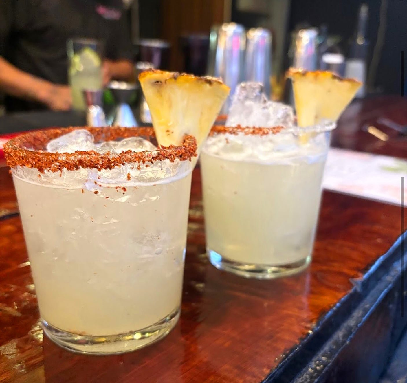 Two lime margaritas garnished with pineapple slices