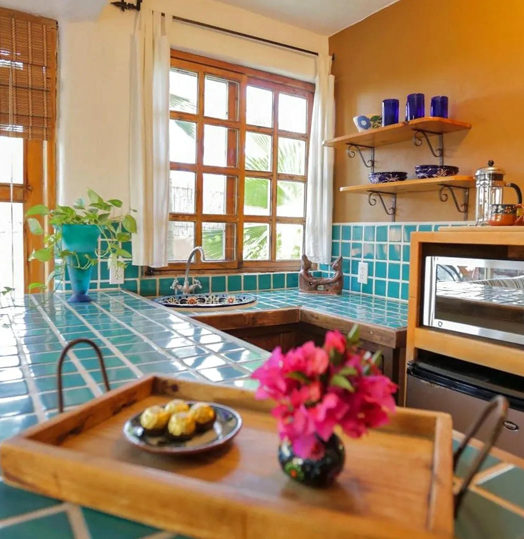 Emerald-tile kitchen countertop with vase of pink bougainvillea